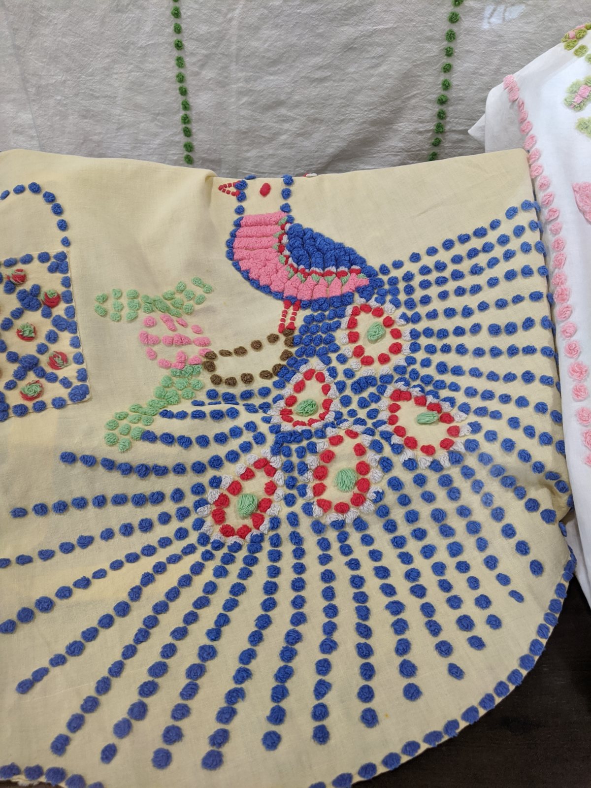 Two peacock chenille bedspreads (yellow ground; white ground with pink peacock)